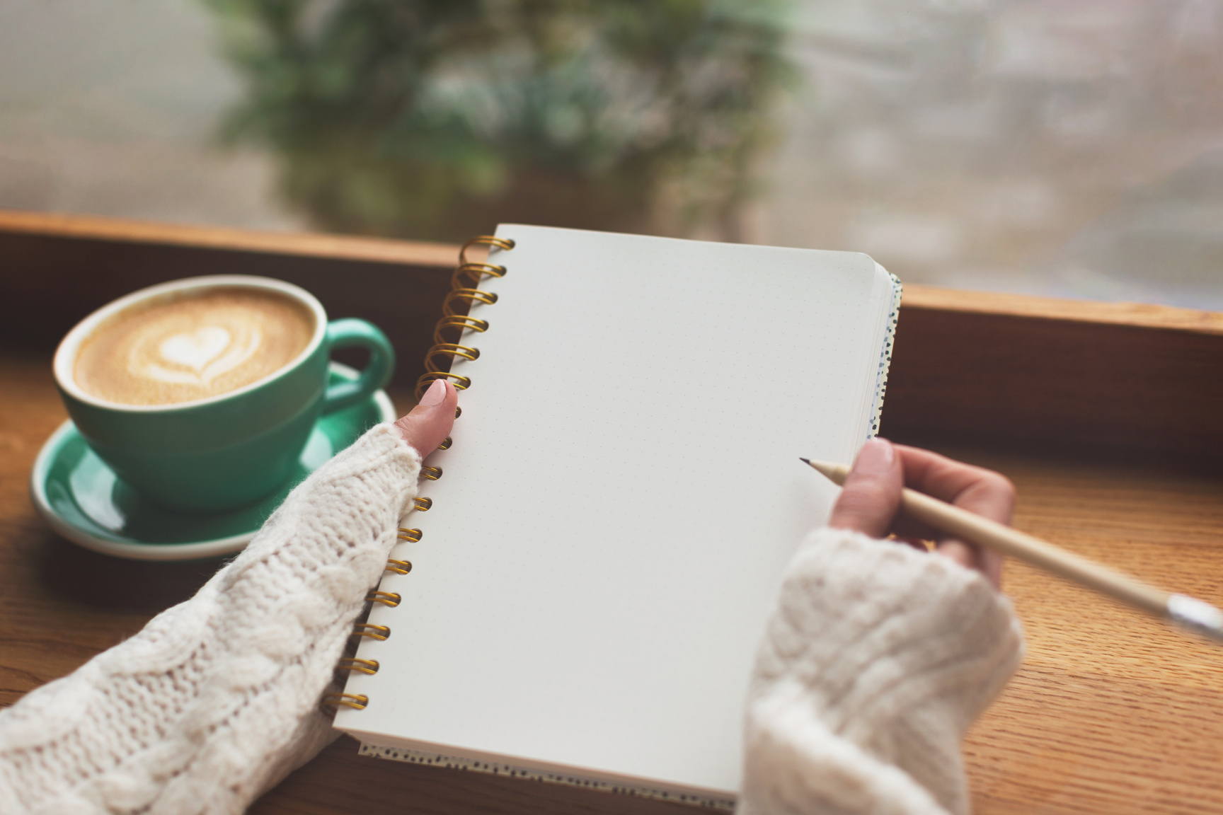 Unidentified Woman Is Writing in the Notepad in Cafe.